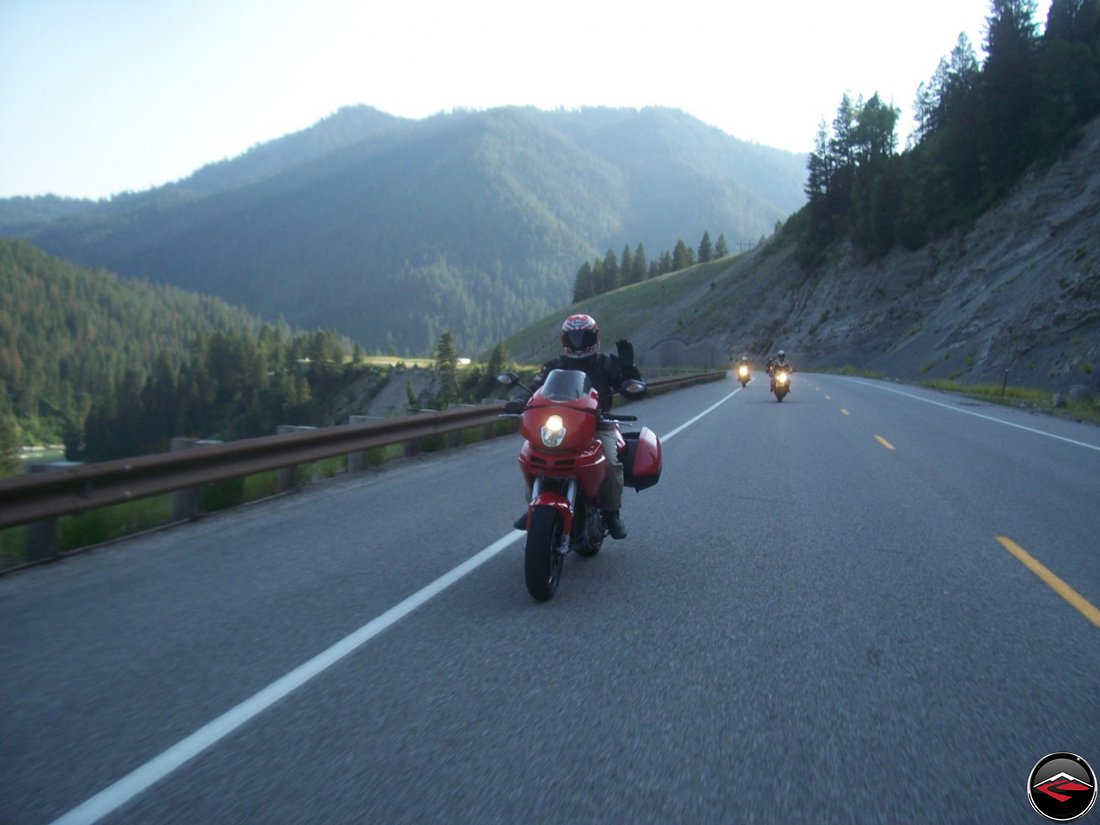 Motorcyle riding waving while riding Snake River Canyon near Alpine, Wyoming