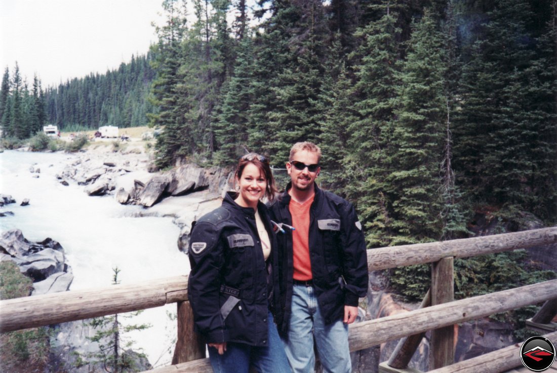 dave and kris standing on a wooden bridge in british columbia canada