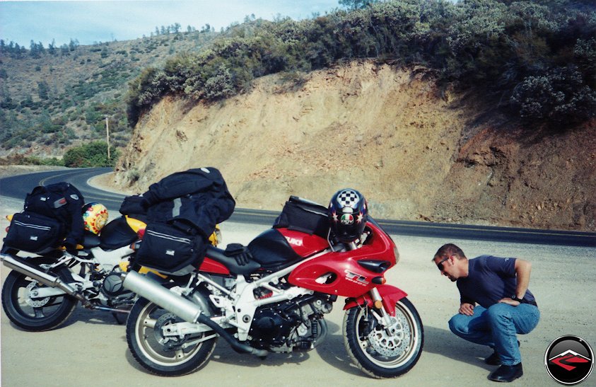 man checking tires on a Honda VTR1000 Superhawk and Suzuki TL1000S in a pullout