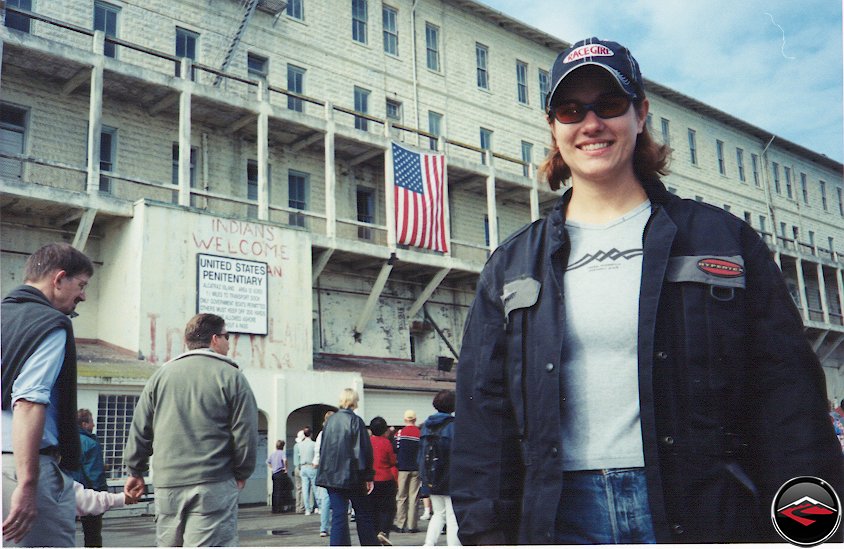 Pretty girl wearing a Race Girl hat and Kilimanjaro jacket standing at the Alcatraz Prison Entrance, Indans Welcome