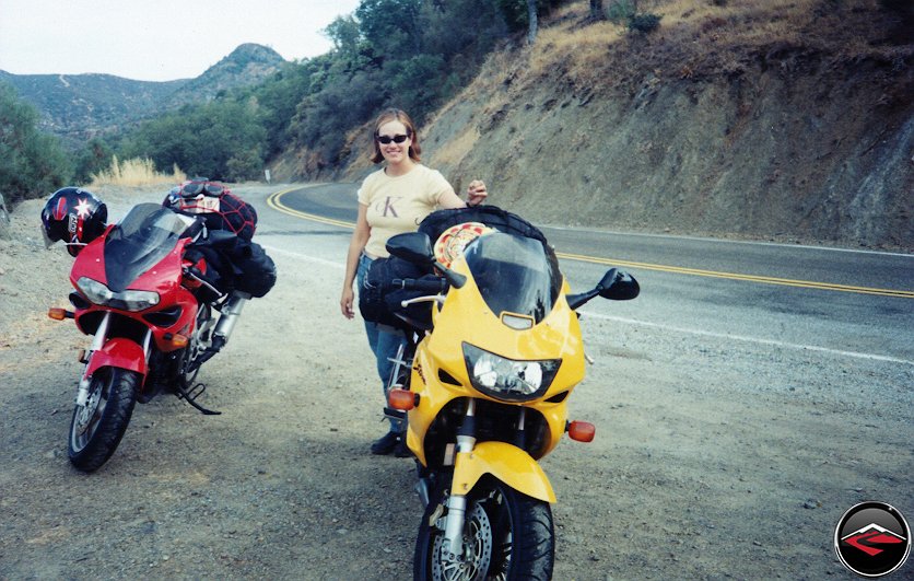 Pretty girl standing next to Honda Superhawk VTR1000 and Suzuki TL1000S