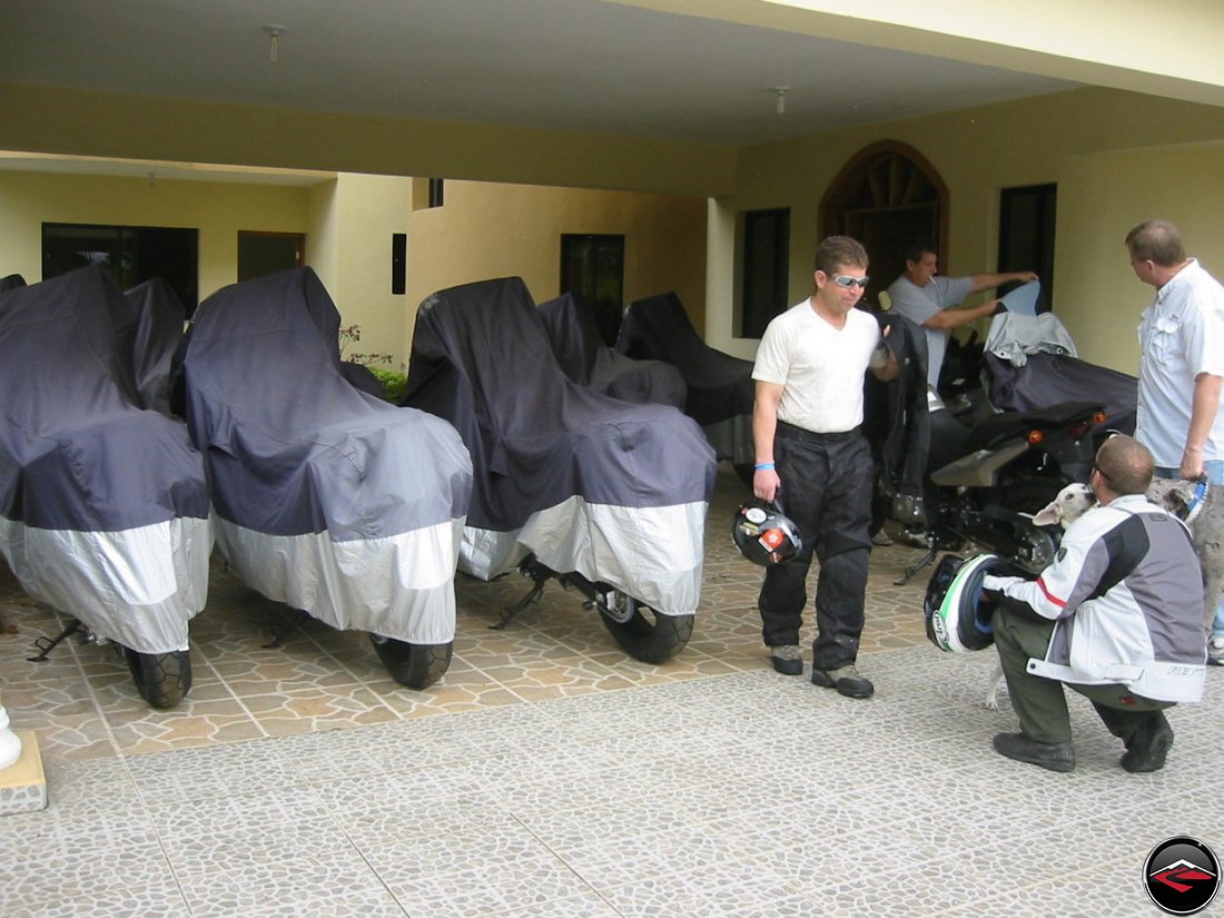 fleet of motorcycles parked underneath tarps