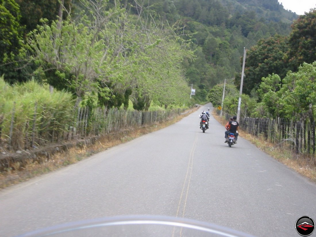 Motorcycles riding down a straight road in the Dominican Republic