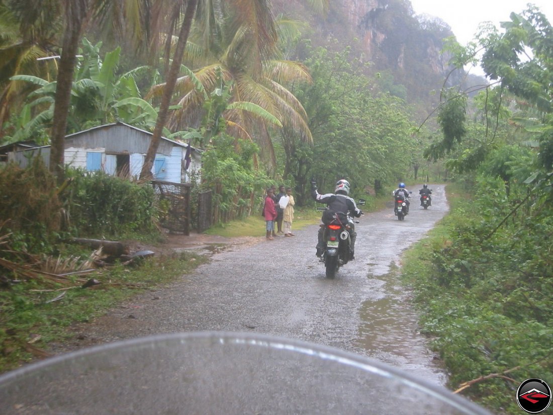 motorcyclist waving to kids on the side of the road