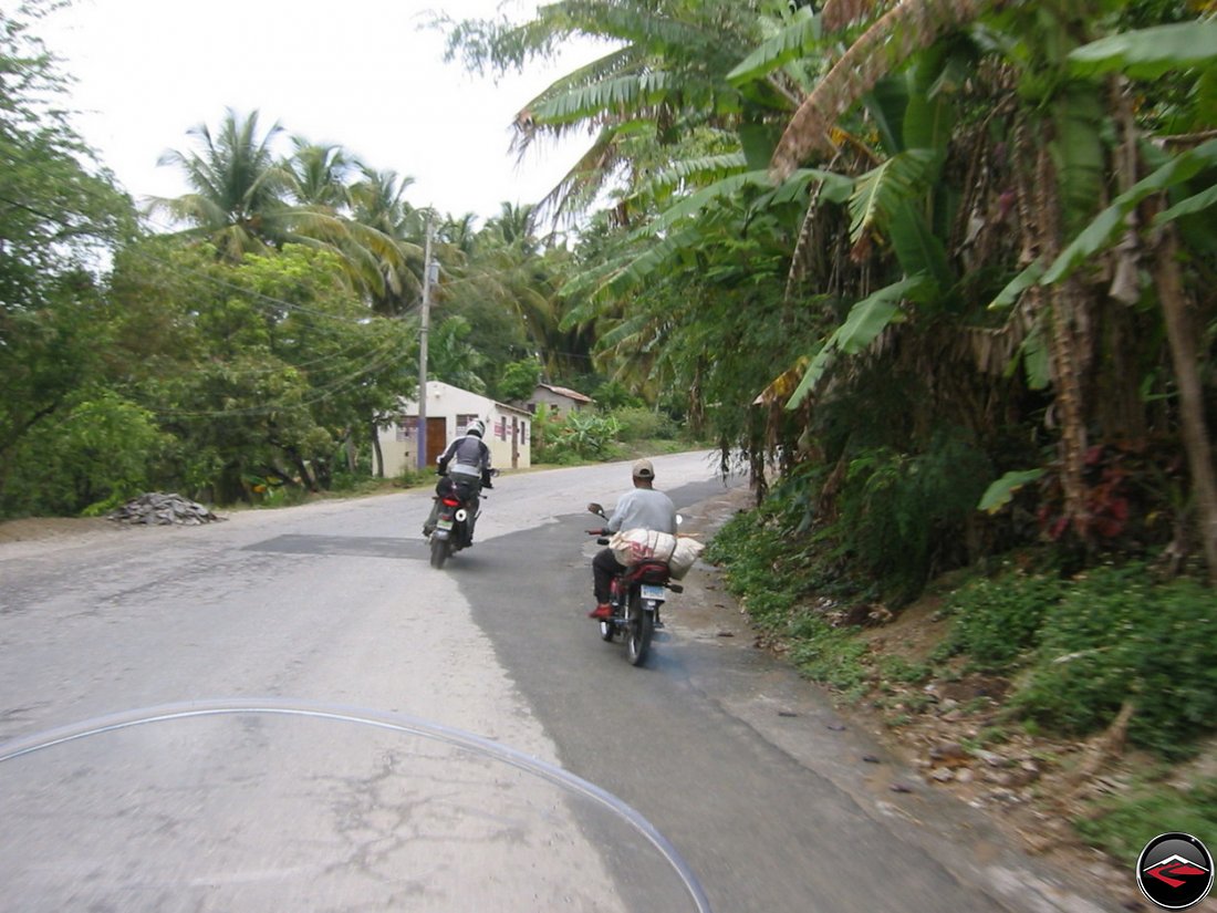 man riding motorcycle standing on footpegs rounding a corner