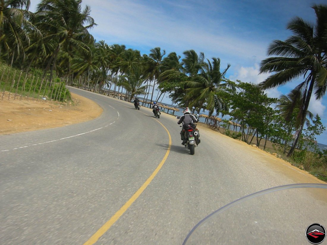 motorcycles riding through an epic corner along the beach in the dominican republic