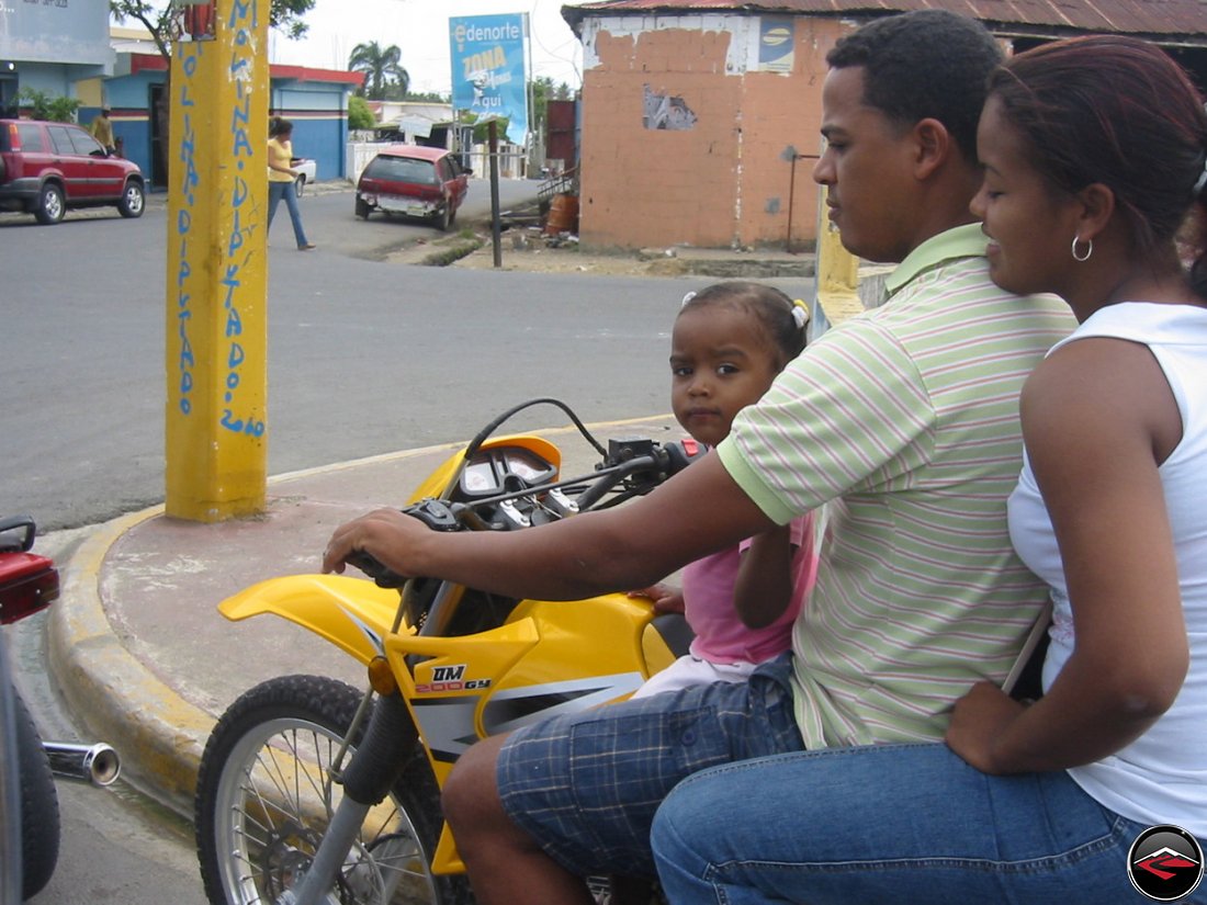 Three people on a small motorcycle in the dominican republic