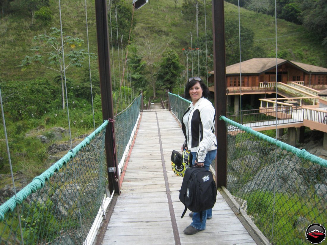 woman Crossing a wood and steel suspension bridge