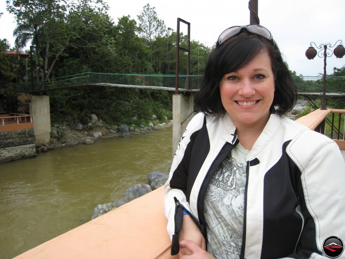 Woman standing in front of a hand-made suspension bridge