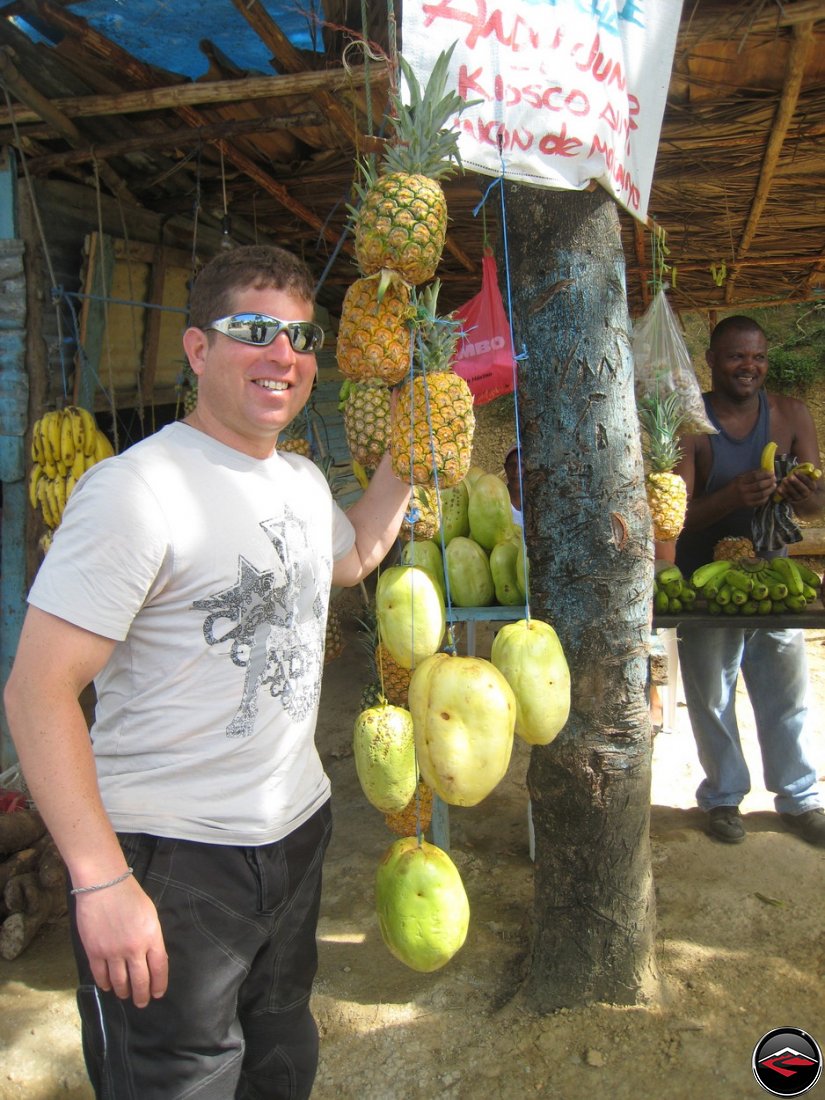 man in front of pineapples