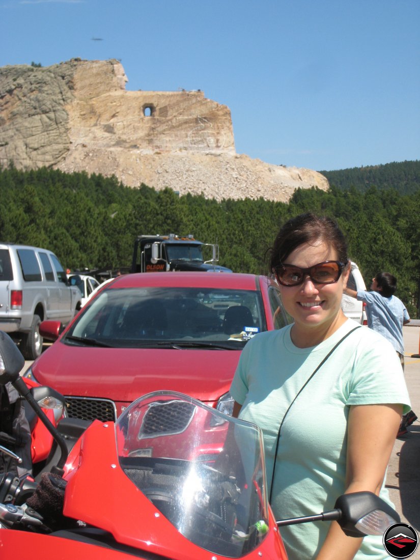 pretty girl standing in front of the unfinished Crazy Horse Monument in South Dakota
