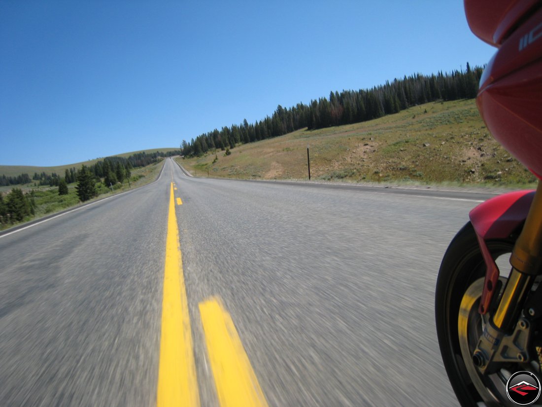 Ducati Multistrada front wheel spinning with the blurred yellow centerline on top of the Big Horn Mountains in Wyoming