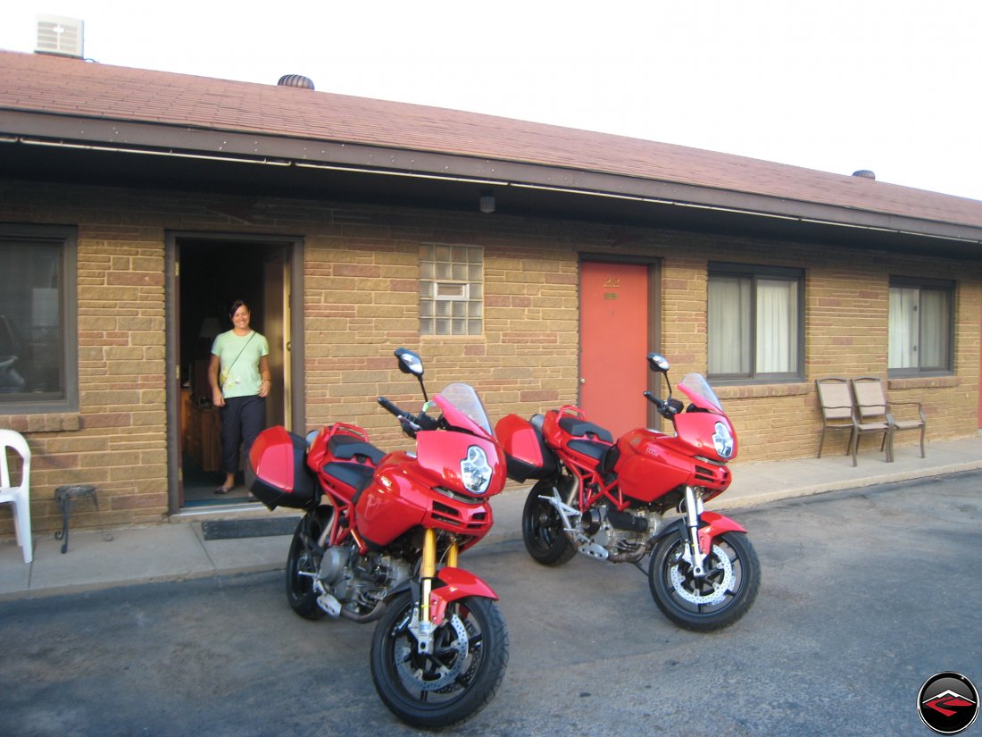pretty girl standing behind two Ducati Multistrada motorcycles at the hotel in Sundance Wyoming