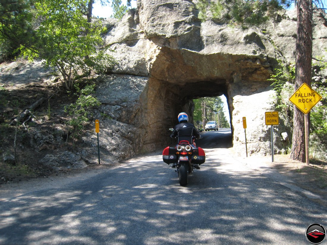 Riding a Ducati Multistrada motorcycle through one of the tunnels on the Norbeck Scenic Byway in South Dakota near Mount Rushmore