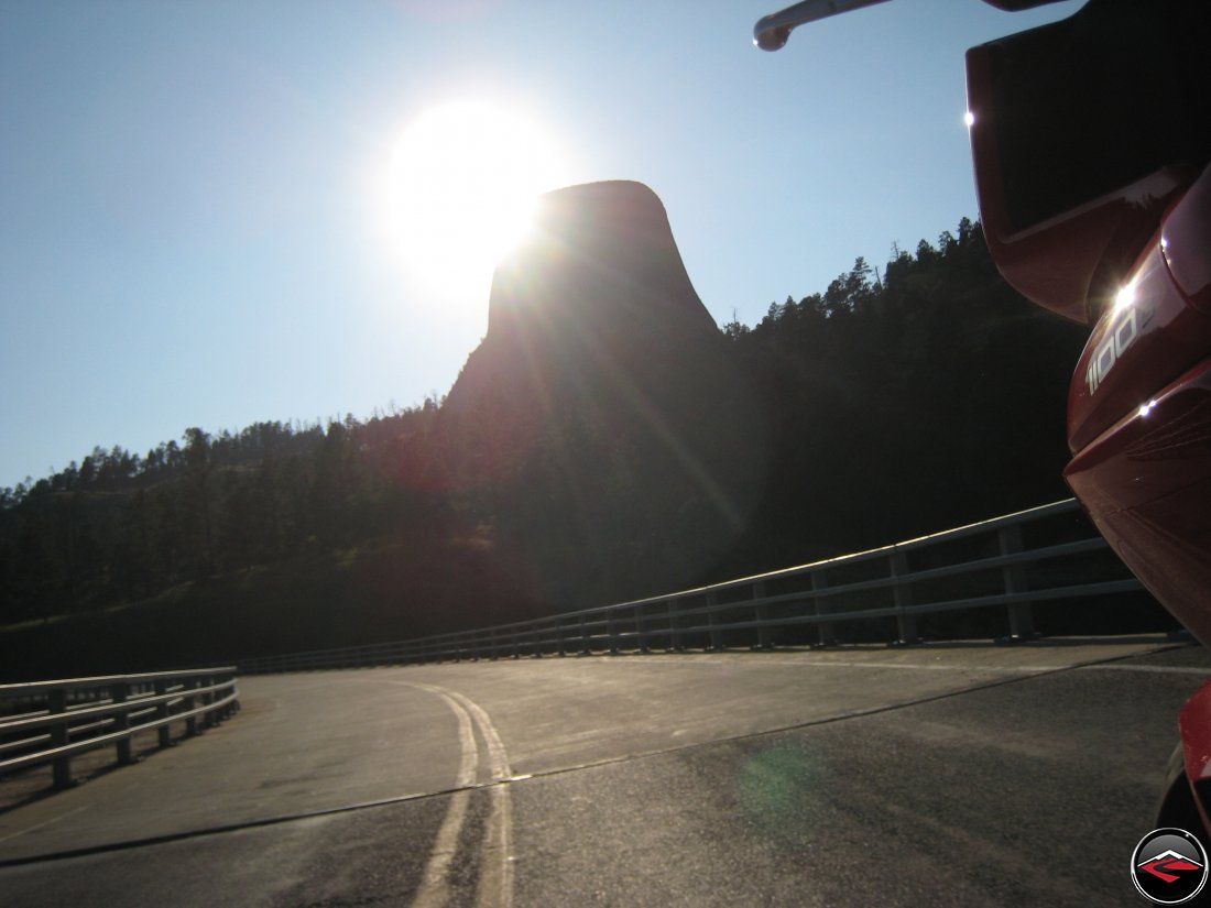 Sun streaks behind Devils Tower near sunset