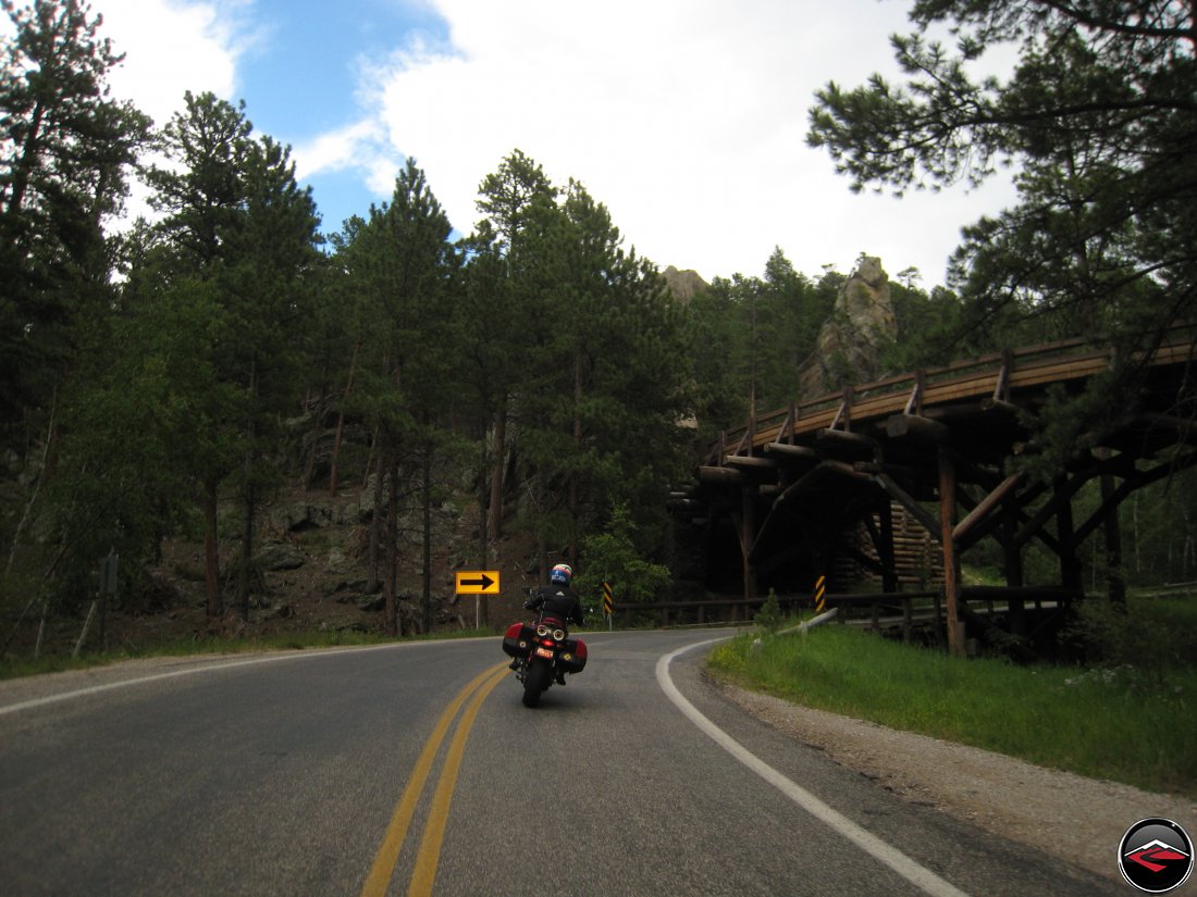 Motorcycle riding around a pigtail bridge on the Norbeck Scenic Byway in the Black Hills of South Dakota