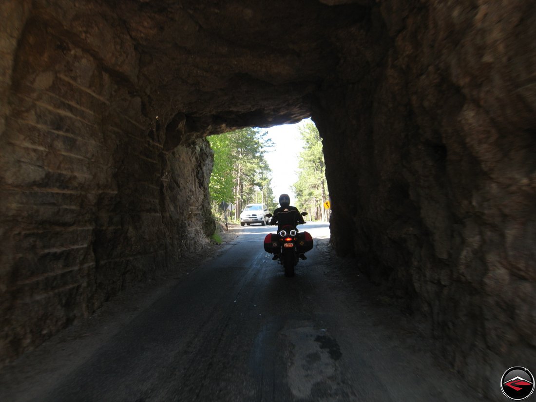 Riding a Ducati Multistrada motorcycle inside one of the tunnels on the Norbeck Scenic Byway in South Dakota near Mount Rushmore