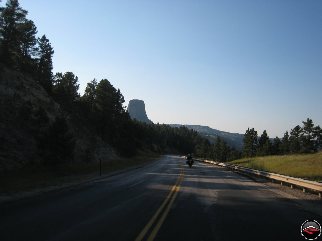 Motorcyclist on a Ducati Mulitstrada riding past Devils Tower in Wyoming