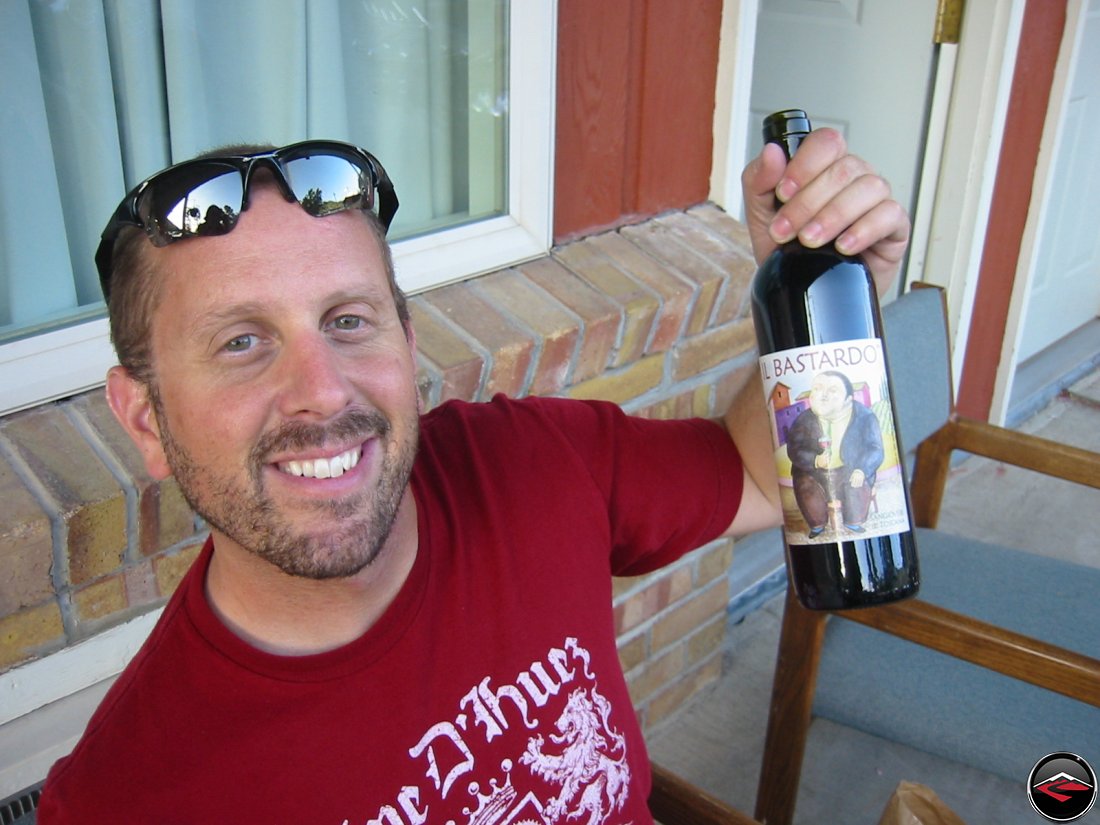 man holding up a bottle of Il Bastardo wine