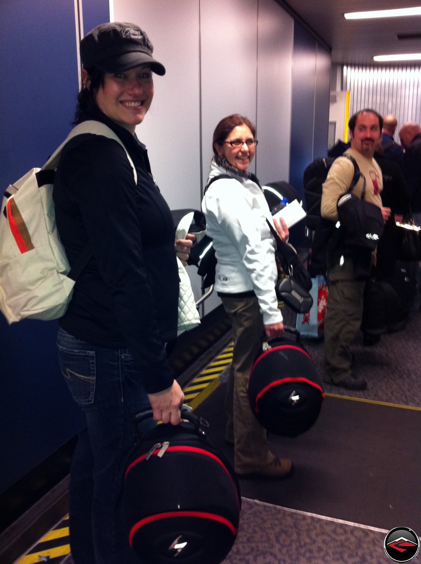 smiling and carrying helmets while boarding our first flight