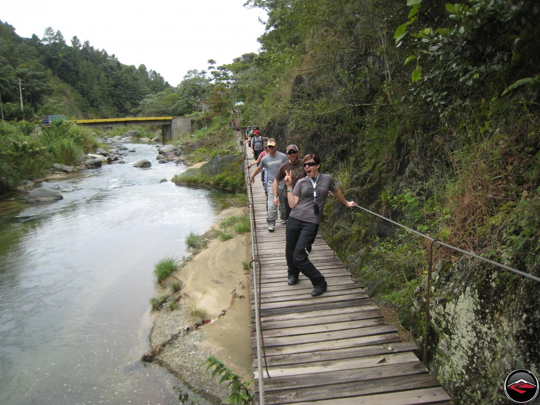 Pretty girl being silly while walking on a wood and cable bridge in the Dominican Republic