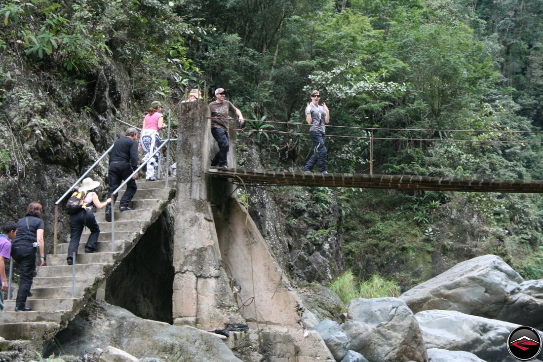 Pretty Girl being silly while walking on a wood and cable bridge with concrete pillars