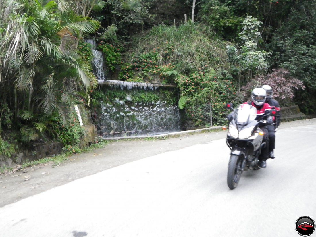 Riding a Suzuki V-Strom 650 motorcycle through a corner in the Dominican Republic