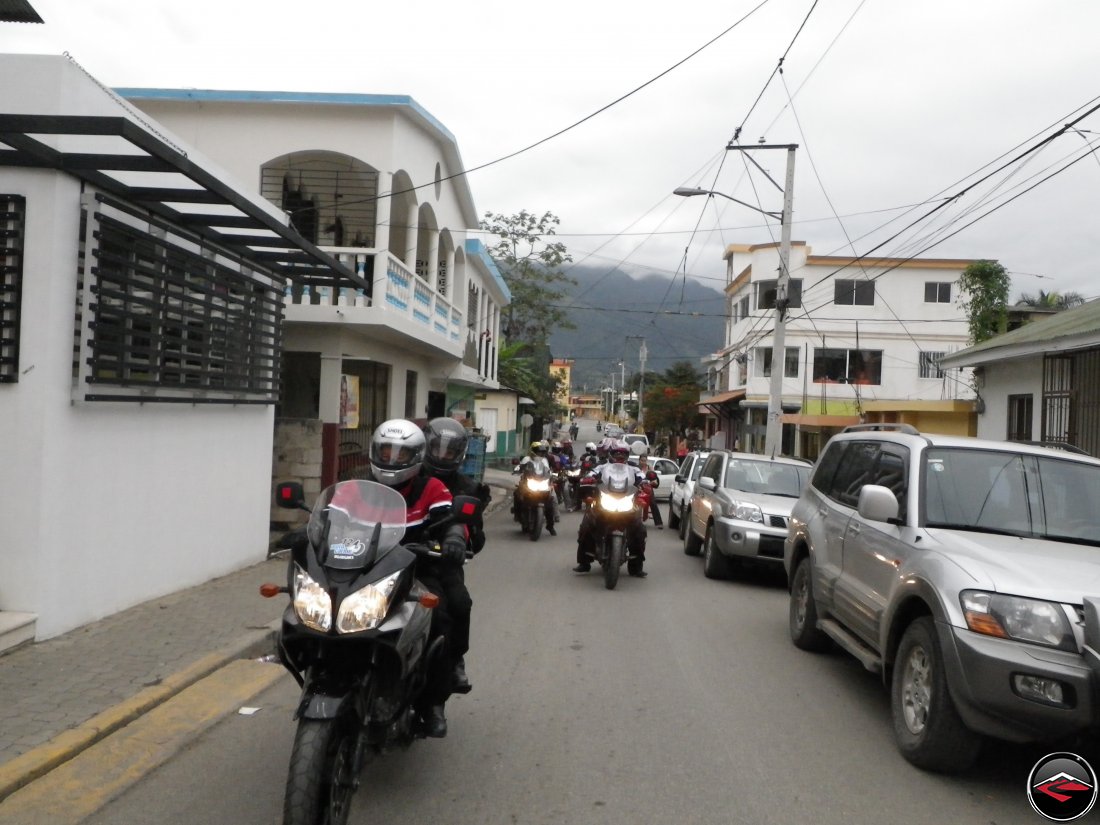 Riding motorcycles down narrow, conjested streeds of a caribbean town
