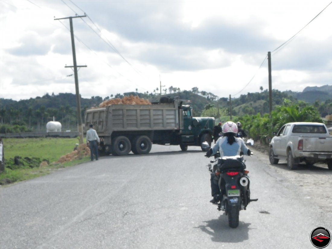 Motorcycles having to stop for a dump truck blocking the road near Sabaneta de Yasica Dominican Republic