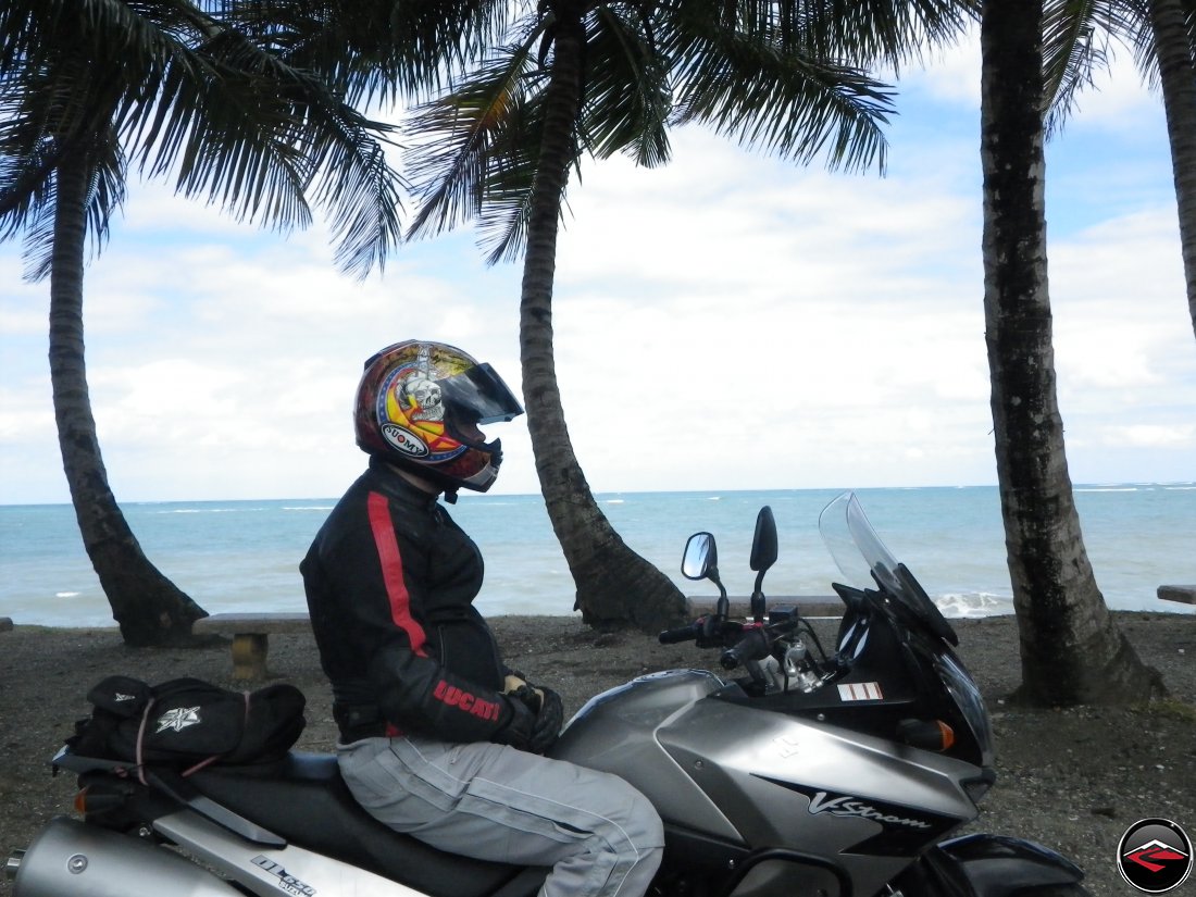 Ryan, wearing a Suomy helmet, sitting on his Suzuki V-Strom 650 Motorcycle