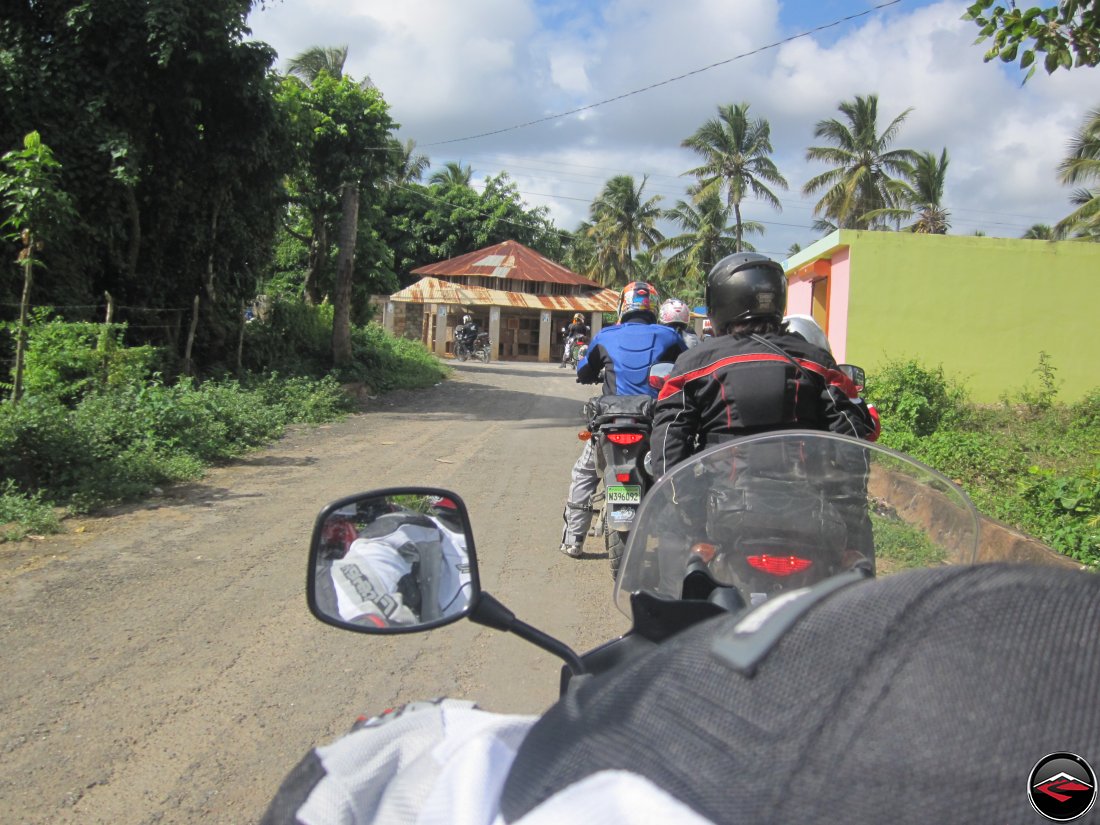 riding motorcycles past small dominican republic buildings
