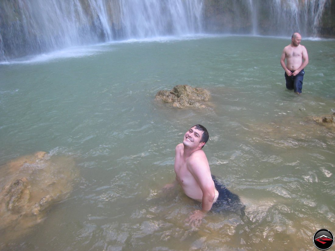 Man posing as a mermaid in front of a waterfall Cascada El Limon Dominican Republic