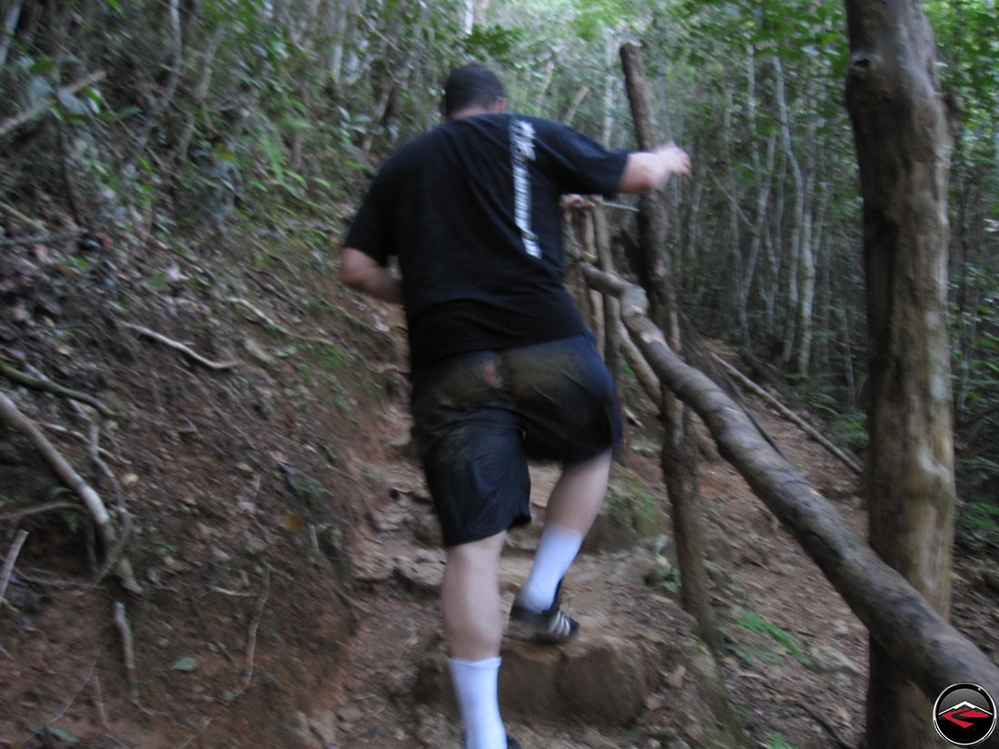 man with a hole in the butt of his shorts hiking up a steep hill Cascada El Limon Dominican Republic