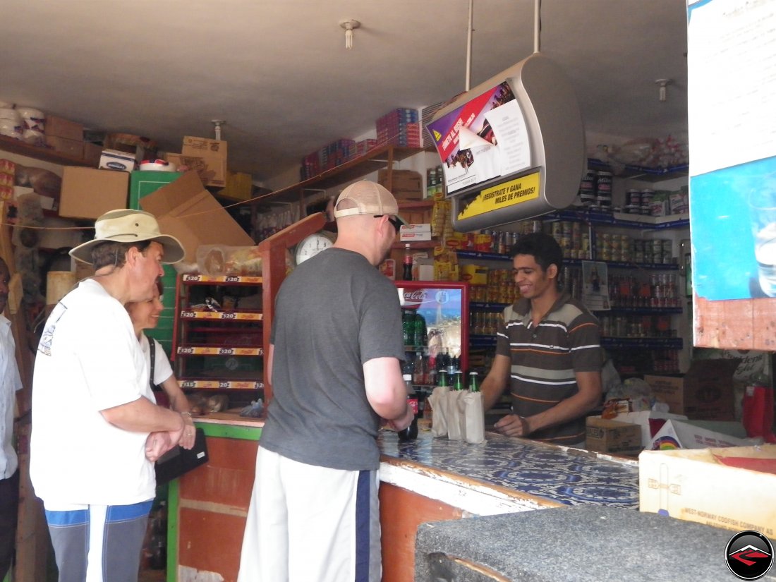 People at the counter of a small caribbean conveinence store