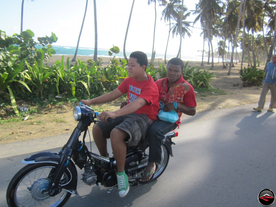 two men riding a honda super-cub in the dominican republic