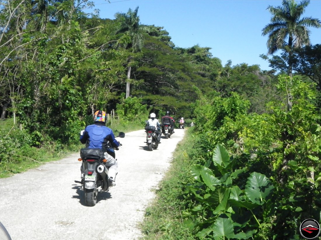 Suzuki V-Strom 650 motorcycles riding on a dirt road on a caribbean island