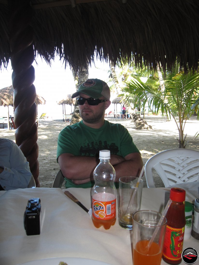 Man having lunch on the beach drinking orange fanta soda