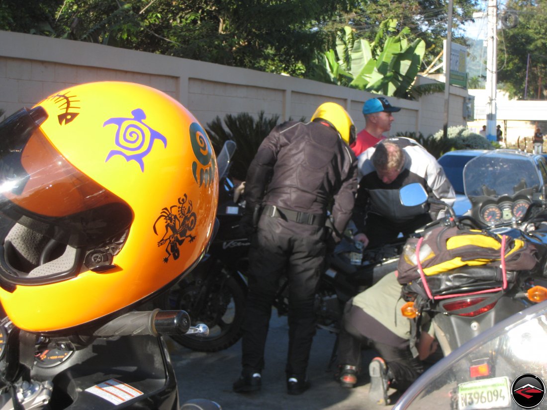 orange motorcycle helmet sitting on a motorcycle mirror