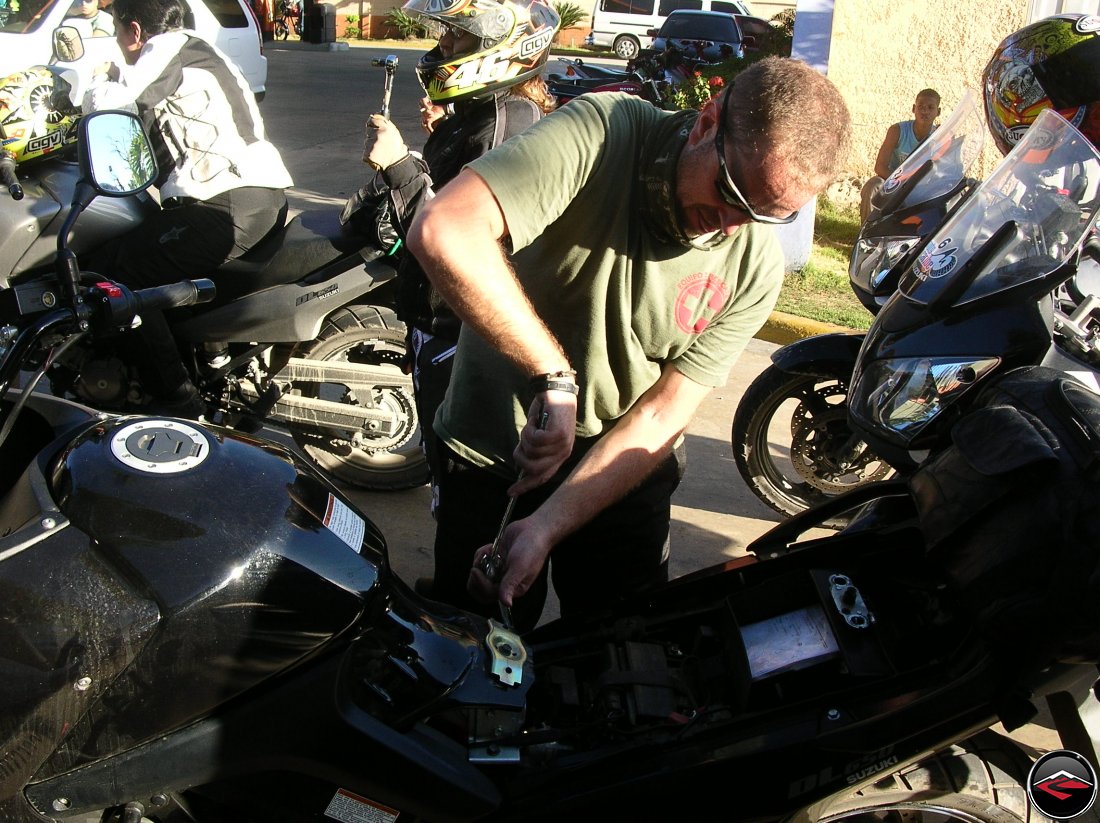 man using two-wrecnhes to tighten a bolt on a Suzuki V-strom 650 motorcycle