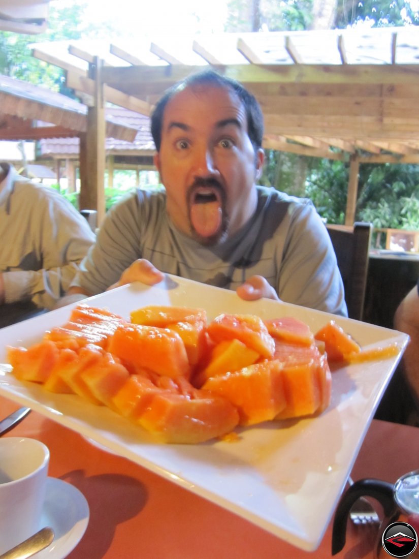 man holding a plate of papaya