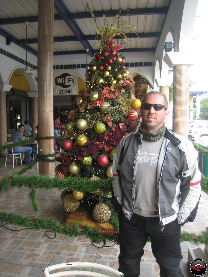 man standing in front of a christmas tree