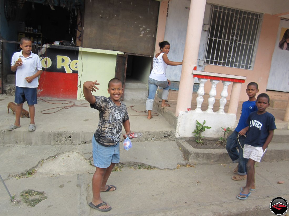 Little boy waving at a girl riding a motorcycle