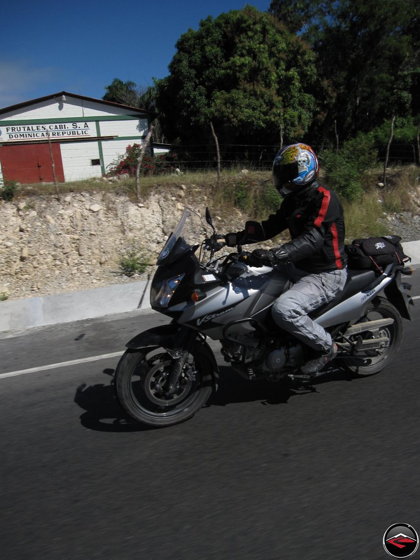 CanyonChaser Ryan man riding a motorcycle past a barn, frutales cabi, s.a. dominican republic