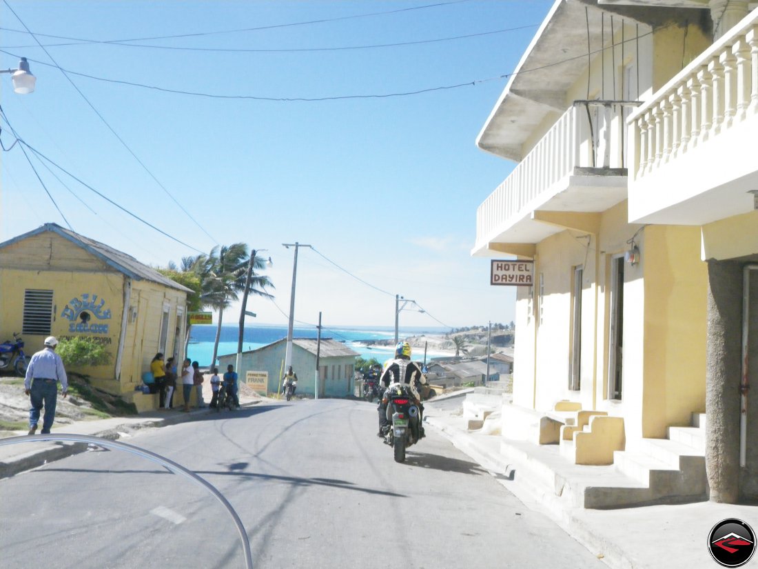 woman riding a motorcycle past caribbean hotel dayira