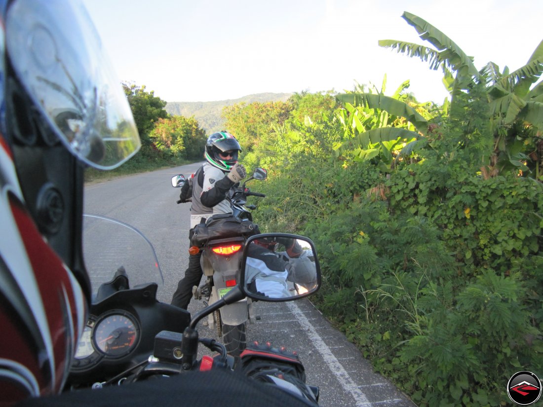 man on stopped motorcycle looking backwards