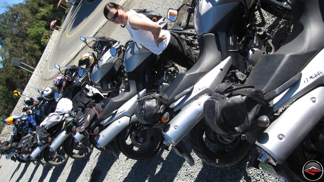 motorcycles parked in a line next to the road