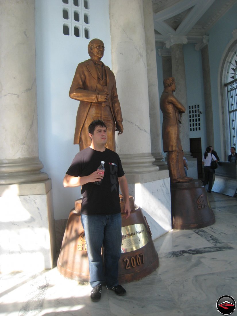 man mimicking copying the statue behind him