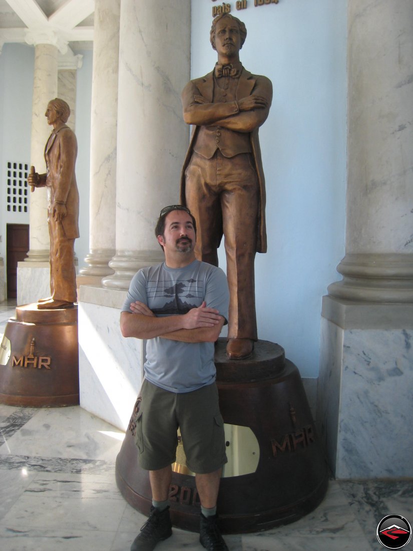 man mimicking copying the statue behind him