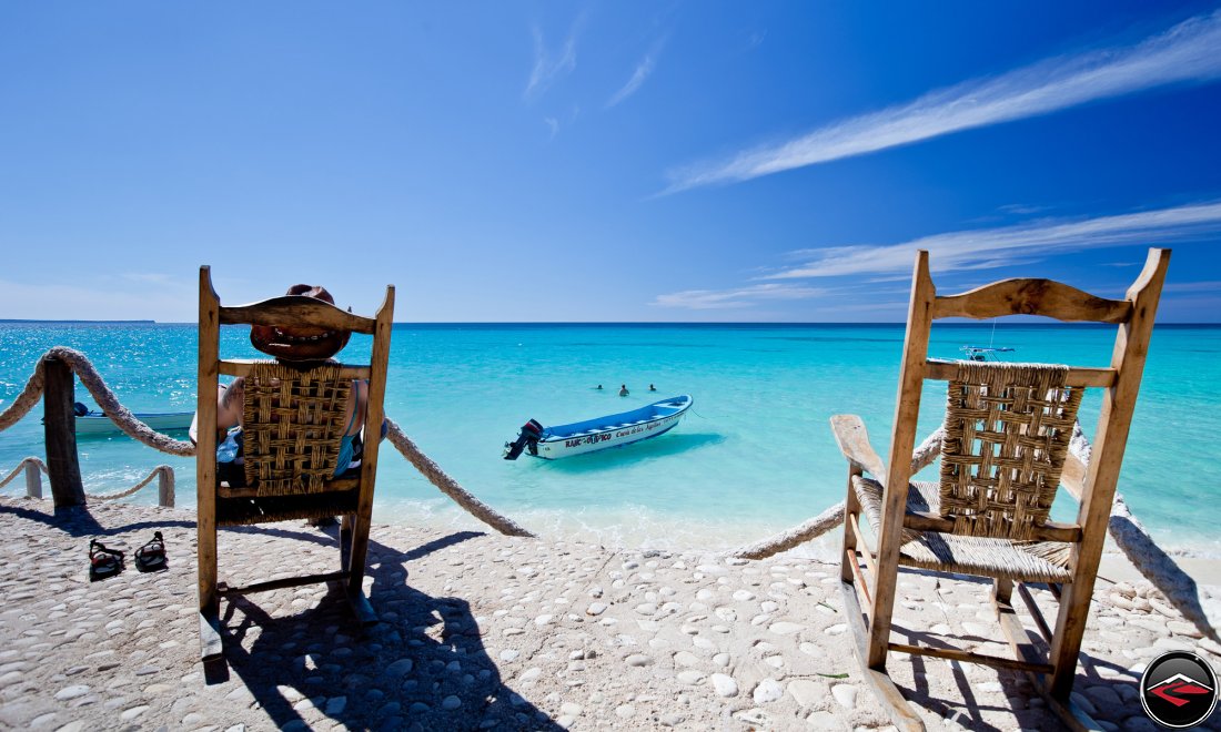 perfect caribbean beach with attractive woman sitting in a beach chair