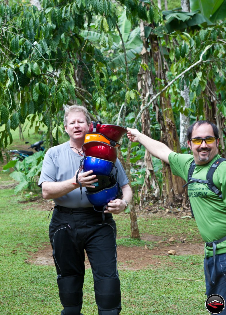 man holding a stack of silly, colorful helmets Cascada El Limon Dominican Republic